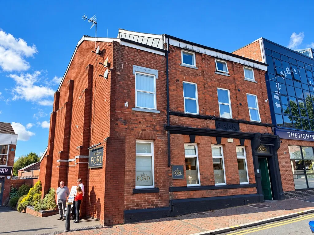 Heddin's Ford, a red-brick building on a corner in Hednesford, with two people standing outside