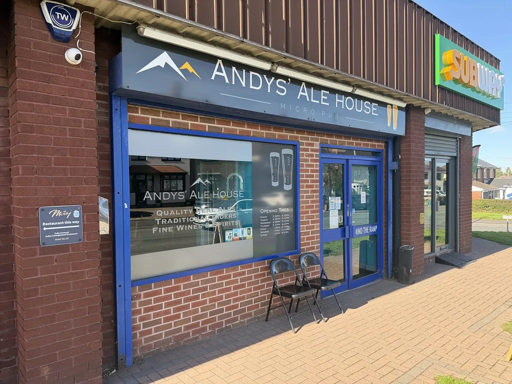 Andys' Ale House, a micropub in a brick-fronted shop unit with a blue-framed window and a bench outside